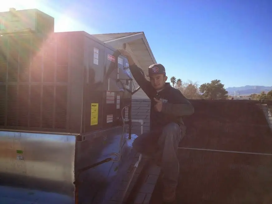 HVAC technician performing Heat Pump Repair on a rooftop unit in Lincoln City